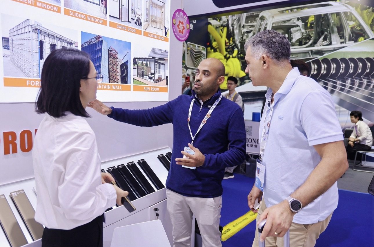 Empresários brasileiros negociando com fornecedora em estande na Canton Fair 2026, com apoio da Travel Business